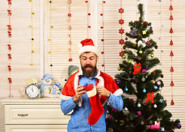 Санта-Клаус с удивленным лицом возле елки — стоковое фото