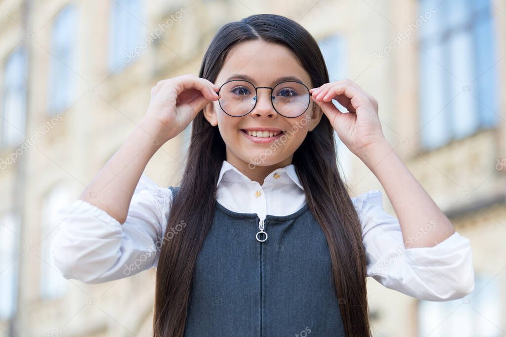 Looking to future. Happy kid fix eyeglasses outdoors. Eye sight development. Child vision. Back to school eye sight test. Pediatric ophthalmology. Primary education. Health and care