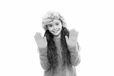 Oyuncu modacı. Uzun saçlı çocuk yumuşak kürk şapkası yumuşaklığın tadını çıkarır. Yumuşak bakım konsepti. Sahte kürk trendi. Uzun saçlı bir kız beyaz kürk şapka takıyor. Yünlü giysiler için yumuşatıcı. Yumuşak duygular