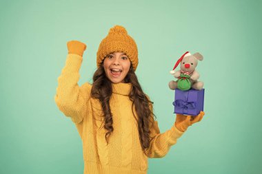 Başarılı fare yılı. Hediyeyle eğlen. Alışveriş ipuçları. Mutlu kız fare oyuncağı ve paketlenmiş hediye kutusu tutuyor. Çocuk süveter ve şapka örüp pelüş oyuncak oynuyor. Çocuklar için alışveriş. Mutlu 2020 yılları. İyi şans için bir hediye.