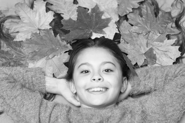 Con sonrisa en los labios. Feliz sonrisa de modelo de belleza. Niño pequeño con linda sonrisa. Niña de humor otoñal. Niño sonriendo con hojas coloridas en el pelo largo. La temporada de otoño comienza con una hermosa sonrisa — Foto de Stock