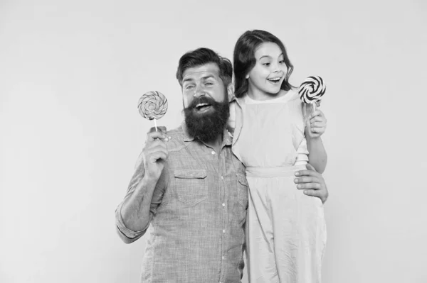 Fille et père mangent des bonbons sucrés. Homme barbu et adorable bébé. Papa et petite fille adorant manger de la sucette. Vacances d'été. Joyeuses fêtes. Jolie enfance. Quand les enfants semblent difficiles à satisfaire — Photo