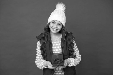 İnternetten alışveriş. Çocuk için küçük bir hediye kutusu. Mutlu çocukluk. Noel hediyeleri. Hediyeler. Kış tatiline hazırlanın. Güzel şeyler yap. Kış kıyafetli mutlu çocuk, kırmızı arka plan. Yeni yıl yaklaşıyor.