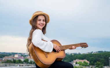 Müzik konsepti. Şarkı söyleyen şarkılar. Yetenekli kız müzisyen. Yaşam Tarzı ve İnsanlar Konsepti. Gitar çalıyor. İp enstrümanı çal. Parti veriyoruz. Akustik gitarlı mutlu çocuk.