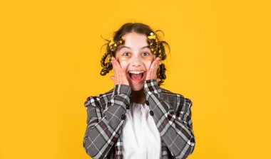 Göz bantlı mutlu çocuk. Saçlarının etrafında kıvırcık kızlar. Güzel bir saç stili yap. Kuaför salonu. Sarı arka planda saç tokası ve saç tokası olan bir kız. Harika bir saç stili.