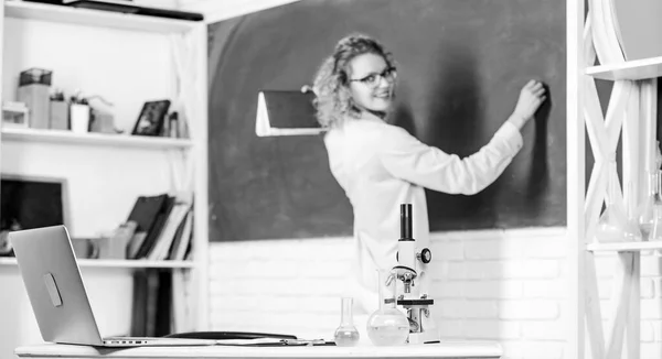 Biology laboratory. Microbiology and bioengineering. Microscope ant tubes with chemical liquids on table school biology teacher selective focus. Student writing chalkboard defocused. Biology concept — Stock Photo, Image