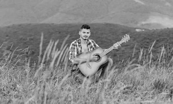 Porque as ruas estão a cantar. música country. homem sexy com guitarra em camisa quadriculada. moda hipster. camping ocidental e caminhadas. feliz e livre. cowboy homem com guitarrista acústico — Fotografia de Stock