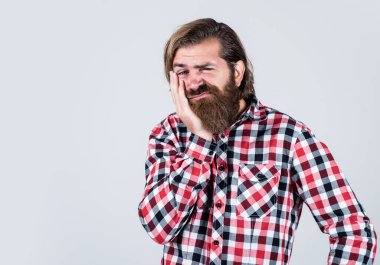 Bıyıklı, vahşi beyaz adam. Sakallı adam kareli gömlek giyer. Acıdan kıvranan acımasız adam. Erkek sağlık hizmetleri. Dişlerin ağrıyor. Sakallı olgun bir hippi diş ağrısı çekiyor.