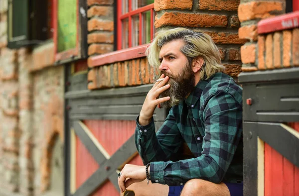 L'habitude de fumer. Un type aux lunettes fumant du tabac. Fumer à l'extérieur. Un homme avec une cigarette. Cool mec relaxant. Réduire le stress. La santé mentale. Hipster fumant vieux fond d'architecture. Cannabis médical — Photo