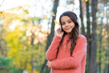 Kendine güveni tam. Sonbahar çalışma zamanıdır. Okula dönüyorum. Online eğitim kavramı. Kazaklı çocuk, dinleme kitabının keyfini çıkar. Yeni teknoloji. Kulaklıklı kız. Çocuk sonbahar parkında müzik dinliyor.