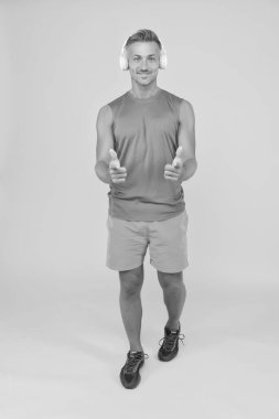 Her zaman hedefi hedef alır. Mutlu sporcu parmakları sarı arka planda. Reklamcılık ve promosyon. Spor salonu reklamı. Fitness yarışması reklamcılığı. Sağlık ve fitness ürünlerinin reklamları