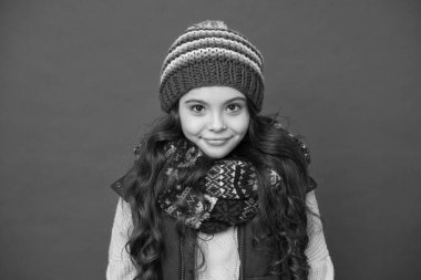 Kışın çok tatlı görünüyorsun. Küçük kız kırmızı arka plan. Kış modasına uygun küçük bir çocuk. Aktif çocuklar için kış kıyafetleri. Tarz ve moda. Kışın sıcak tutun.