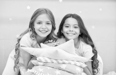 Bütün gün pijama. İyi sabahlar. Küçük kızlar için şirin, rahat bir yatak odası. Kız kardeşler yatak odasının içinde eğleniyor. Çocukluk konsepti. Yatak odası dinlenme ve dinlenme yeri. Pijamalı çocuklar. Evde kal.
