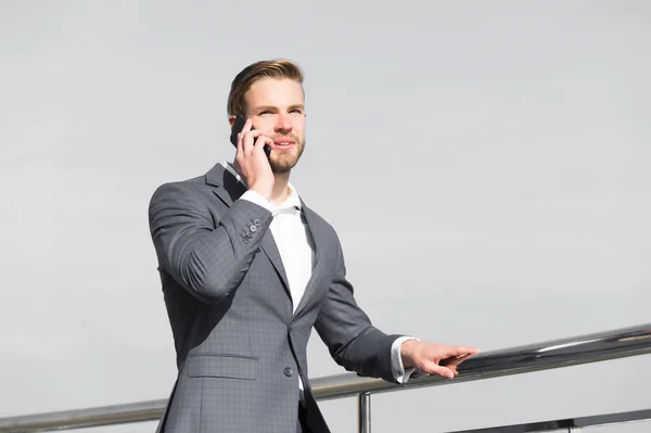 Man med smartphone på terrassen på blå himmel, affärskommunikation — Stockfoto