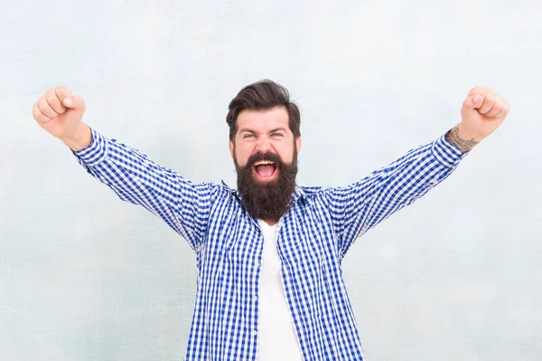 Счастливый бородатый мужчина праздновать победу сохраняя руки вверх пальцы сжаты победный жест синий фон, победитель — стоковое фото
