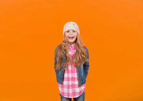 Menina de jeans terno, chapéu, camisa xadrez no fundo laranja — Fotografia de Stock