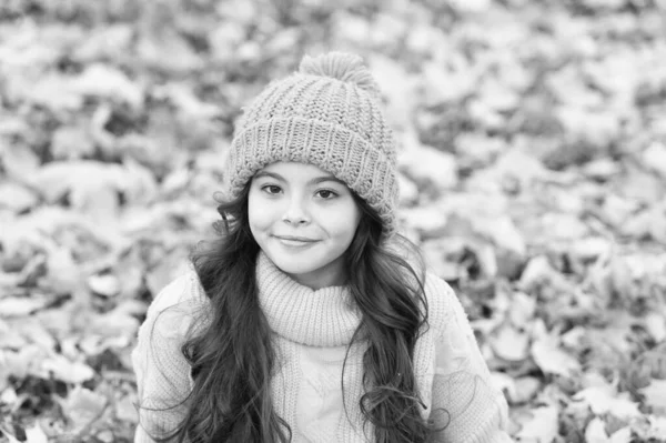 Güzel mevsim. Bu sonbaharda en sıcak tutun. Açık havada sarı şapkalı bir çocuk. Sonbahar cilt bakımı rutini. Çocuk kalın örülü şapka takıyor. Sıcak yün aksesuar. Uzun saçlı kız gülen surat, güz doğası.