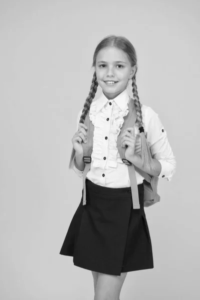 Κοριτσάκι με στολή κουβαλάει σακίδιο. Καθαρή ομορφιά. Παιδί μετά τα μαθήματα. στυλ σχολικής μόδας. έξυπνος μαθητής με κίτρινο φόντο. σύγχρονη εκπαιδευτική έννοια. Πίσω στο σχολείο. — Φωτογραφία Αρχείου