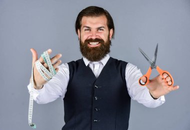 Şuna bak. Vahşi adam moda tasarımcısı. Erkekler için tasarım yapan bir adam. Başarılı sartor çalışmaya hazır. Resmi ve ofis tarzı. Mezura ve makasla terzi. Erkek kıyafetleri giyen bir adam.