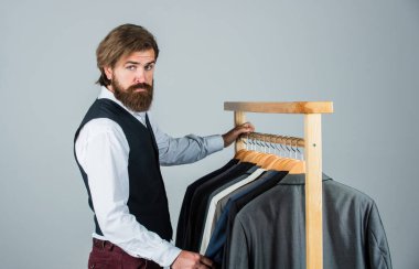 Mezura takan yakışıklı bir sartor. Erkek güzellik ve moda. Sakallı adam, terzi kıyafetleri. Resmi ve ofis kıyafetleri. İş adamı. Kendine güvenen terzi erkek ceketi tasarlıyor. Moda ilham perisi aranıyor