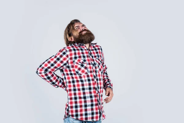Egy fickó, akinek fáj a háta. egészségügyi problémák. A szenvedő embernek hátfájása van. boldogtalan szakállas férfi kockás ingben. férfi egészségügyi koncepció. Szakállas hipszter portréja — Stock Fotó