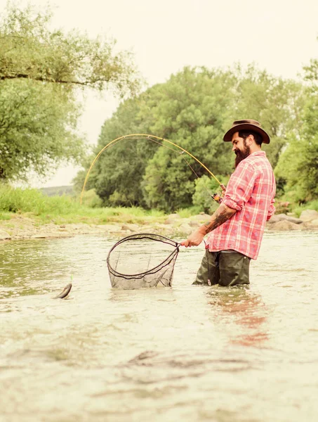Εκτός ορίων για ψάρεμα. γενειοφόρος ψαράς στο νερό. ώριμος άντρας πετάει για ψάρεμα. Ο άνθρωπος πιάνει ψάρια. χόμπι και αθλητική δραστηριότητα. Ποθάντερ. καλοκαιρινό Σαββατοκύριακο. Ψάρεμα. ψαράς με καλάμι — Φωτογραφία Αρχείου