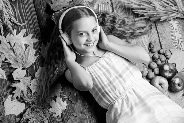 Os sons e ritmos inspirados pelo outono. Uma menina a ouvir música. Menina pequena usando fones de ouvido estéreo. Adorável fã de música no fundo do outono. Bonito criança gosta de música tocando em fones de ouvido — Fotografia de Stock