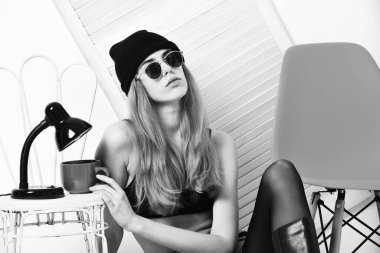 Turuncu güneş gözlüklü, açık yeşil sandalyeli güzel seksi kadın.