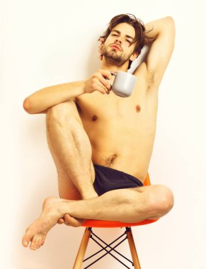 Kafkas sakallı seksi maço elinde kahve fincanı tutuyor.