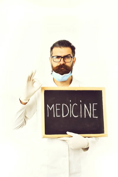 Brodaty lekarz kaukaski trzymający strzykawkę i deskę z napisem "Lekarstwo" — Zdjęcie stockowe