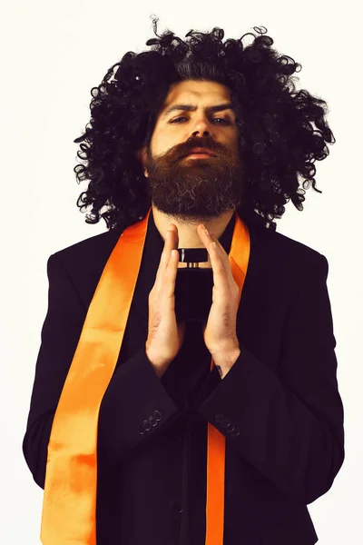 Caucasian hipster in suit and black curly wig holding perfume — Stock Photo, Image