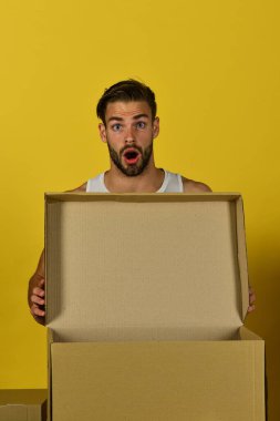 Elinde boş karton kutu tutan kıllı bir adam.