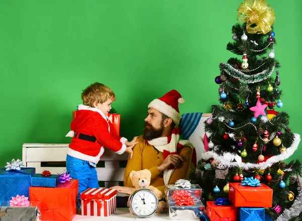 サンタとクリスマスツリーの近くのギフトボックスの間で少しアシスタント. — ストック写真