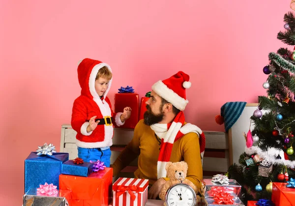 Santa y pequeño asistente entre cajas de regalo. Hombre con barba —  Fotos de Stock