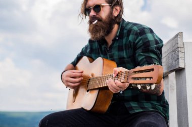 Sakallı olgun hippi müzisyen. Gitar çalan vahşi beyaz adam. Country müziği. Sakallı adam şarkı söylüyor. Yakışıklı şarkıcı ve gitarist. Akustik gitarist. sigara tiryakisi