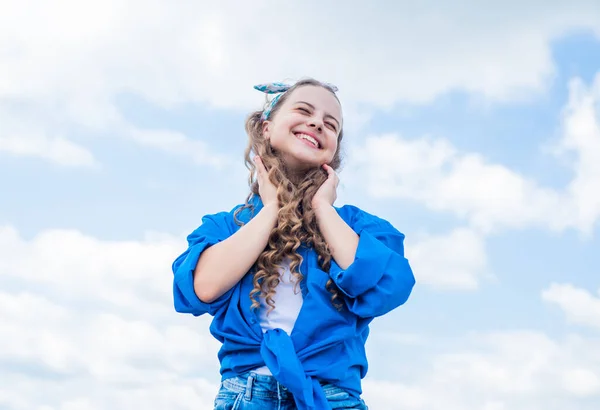 Heureux jour des enfants. bonne enfance. enfant souriant avec coiffure bouclée. beauté et soin des cheveux. style gosse mode. adolescente sur fond de ciel extérieur. Un gamin branché. Soins du visage — Photo