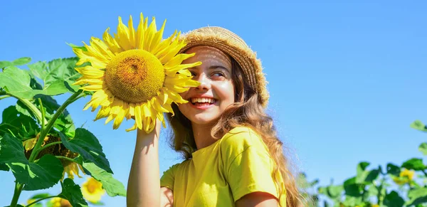 Vive brillantemente. niña en el campo de girasol de verano. Feliz día de los niños. felicidad infantil. retrato de niño feliz con hermoso girasol. niño alegre en sombrero de paja entre flores amarillas —  Fotos de Stock