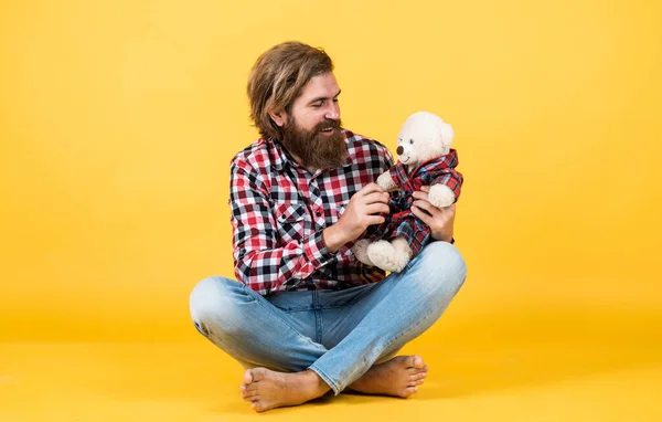 Amizade. brutal maduro hipster homem jogar com brinquedo. Feliz aniversário. estar de bom humor. Feliz Dia dos Namorados. homem barbudo alegre segurar ursinho. masculino sentir brincalhão com urso — Fotografia de Stock