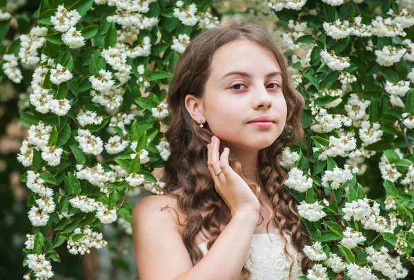 Menina bonita cabelo encaracolado longo primavera flores fundo, inspirado no conceito de natureza — Fotografia de Stock