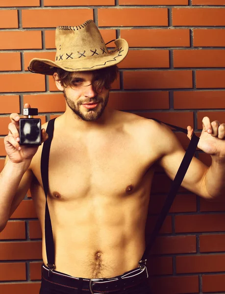 Caucásico barbudo sexy macho hombre en vaquero sombrero celebración perfume — Foto de Stock