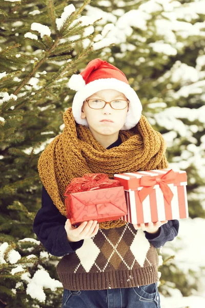 Маленький мальчик с коробками в настоящее время в зимний открытый — стоковое фото