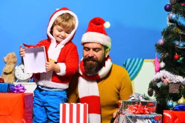 Mutlu çocuk Noel Baba 'yla hediye kutusunu açıyor.