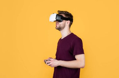 Başka bir gerçeklik burada. VR kulaklıklı bir erkek. Oyuncu modern teknolojiyi kullanır. Dijital gelecek ve yenilik. Görsel gerçeklik. Kablosuz VR gözlüklü adam. Adam video oyunu oynuyor. konsollu oyun oynatıcı