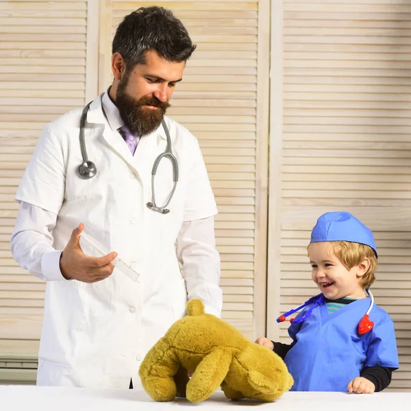 Padre e hijo con caras sonrientes jugando al doctor. —  Fotos de Stock