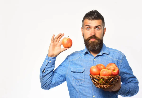 Фермер с удивленным лицом держит красные яблоки — стоковое фото