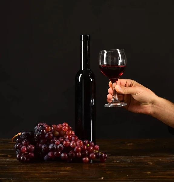 Garrafa e copo de vinho sobre fundo marrom escuro. — Fotografia de Stock