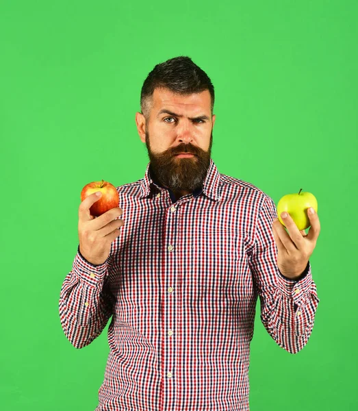 Ο άντρας με μούσι κρατάει κόκκινα και πράσινα μήλα. — Φωτογραφία Αρχείου