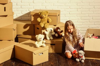 Karton kutular yeni eve taşınıyor. Oyuncağı olan mutlu küçük bir kız. Yeni bir yaşam alanı satın almak. Yeni evimizde oynuyoruz. Yeni daire. Mutlu çocuk karton kutusu. Elinden gelenin en iyisini yapmanın keyfi