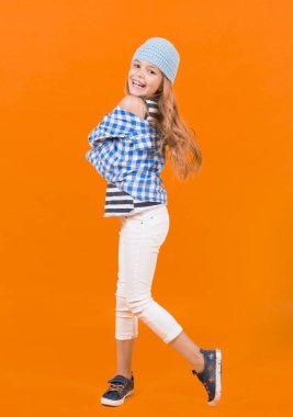 Uzun sarı saçlarıyla gülümseyen bir çocuk.