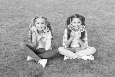 Şeker mutluluğun eşanlamlısıdır. Şeker ve kalori. Neşeli neşeli arkadaşlar dışarıda tatlı yiyorlar. Tatil yemeği. Tatlı çocukluk. Mutlu çocuklar şeker tutarken yeşil çimlerde otururlar. Şekerci. Lolipop ikramları